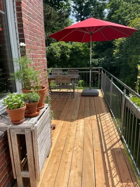 Holzterrasse mit Sitzbereich und Sonnenschirmen