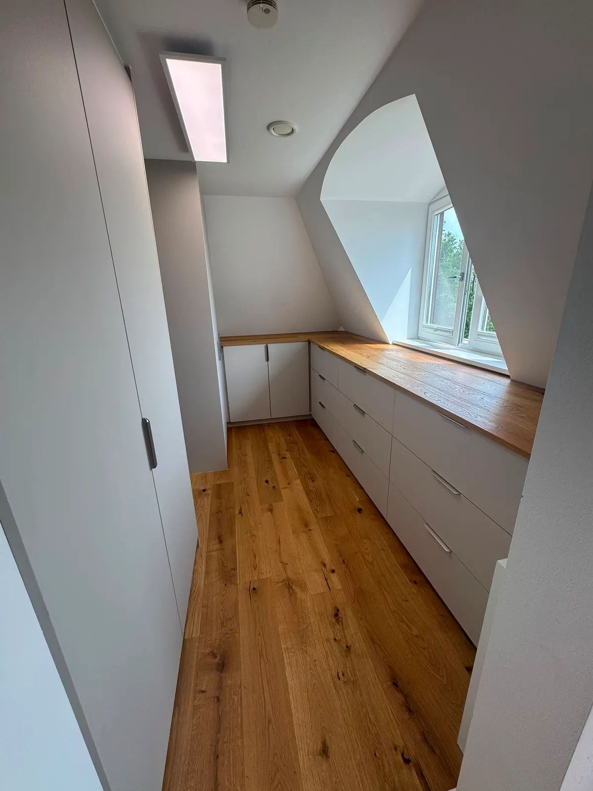 Einbauschrank unter der Dachschräge im Flur mit Ablage aus Holz