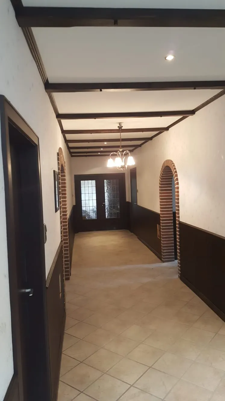 Sanierter Flur mit freigelegten Holzbalken an der Decke