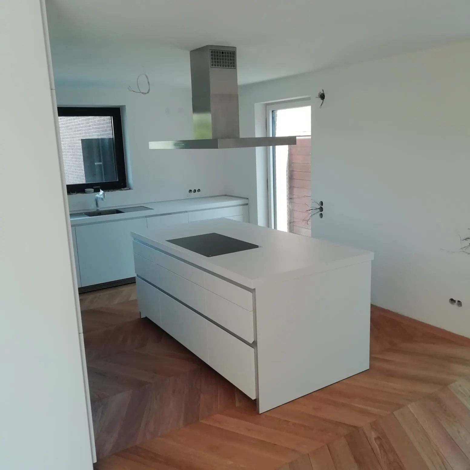Weiße Kochinsel mit Dunstabzug im offenen Wohnraum