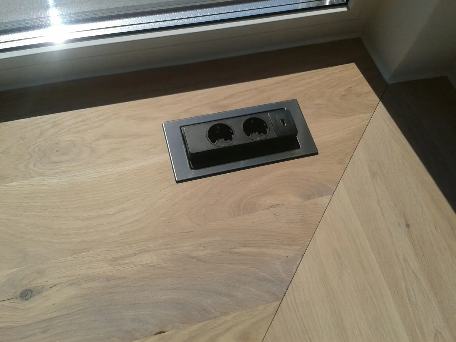 Detail: Arbeitsplatte aus Holz mit versenkbarer Steckdose